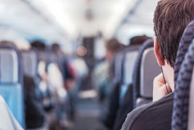 Interior of a train with grey seats and passengers blurred in the background.