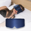 Woman asleep wearing the navy BOLLSEN Deep Sleep Mask, with the silk mask shown in the foreground