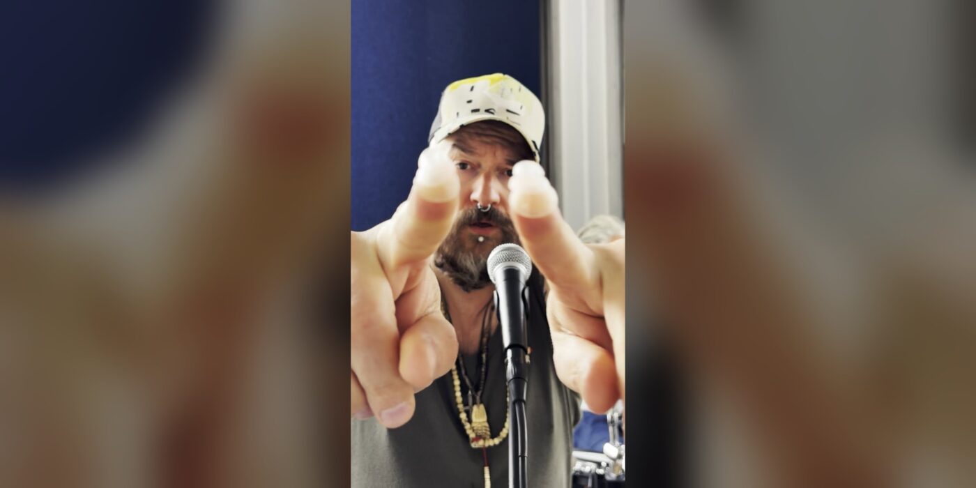 XPQ-21 singer holding up earplugs at the microphone